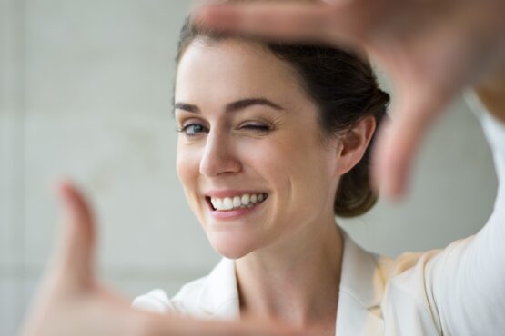 Closeup of Smiling Woman Making Frame Gesture