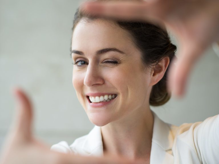 Closeup of Smiling Woman Making Frame Gesture
