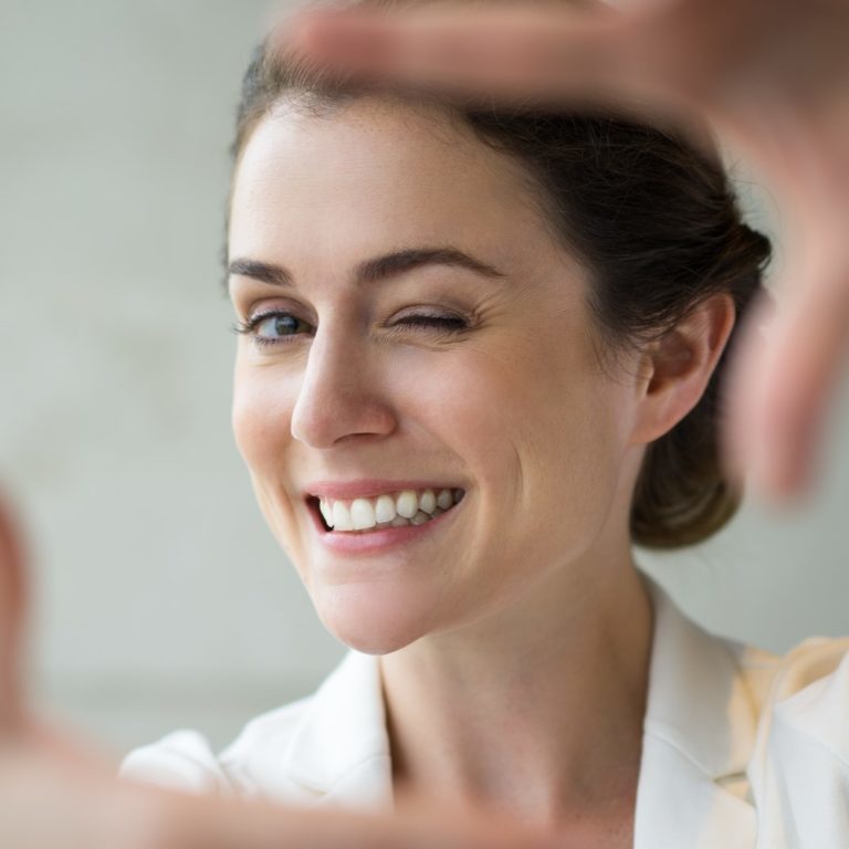 Closeup of Smiling Woman Making Frame Gesture