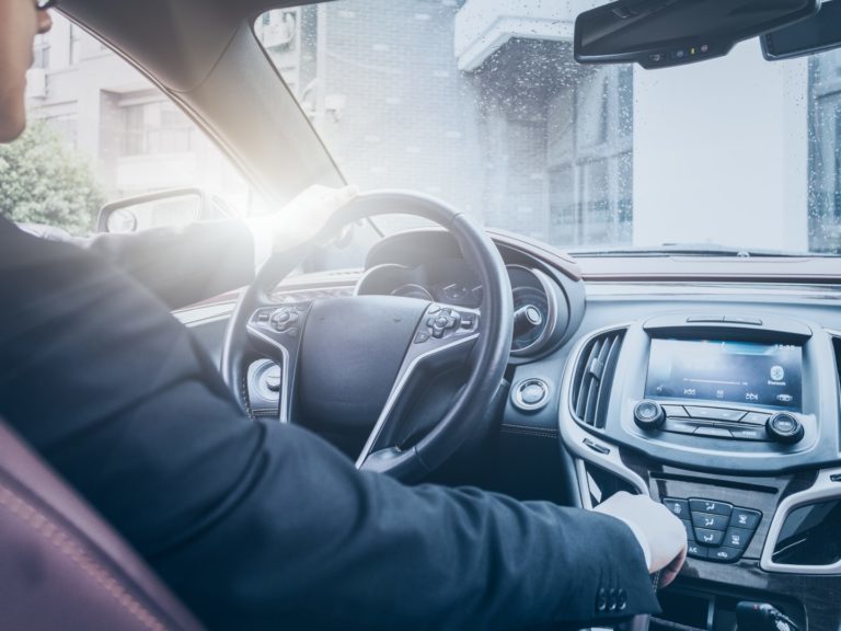 detail shot of young businessman driving his car.