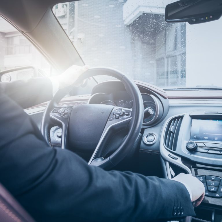 detail shot of young businessman driving his car.
