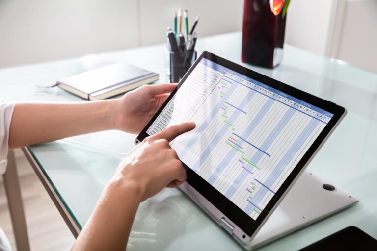 Person bearbeitet digitale Fahrtenbuch-Vorlage auf Tablet im Büro